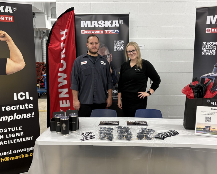 Équipe RH derrière une table lors d'un événement carrière.