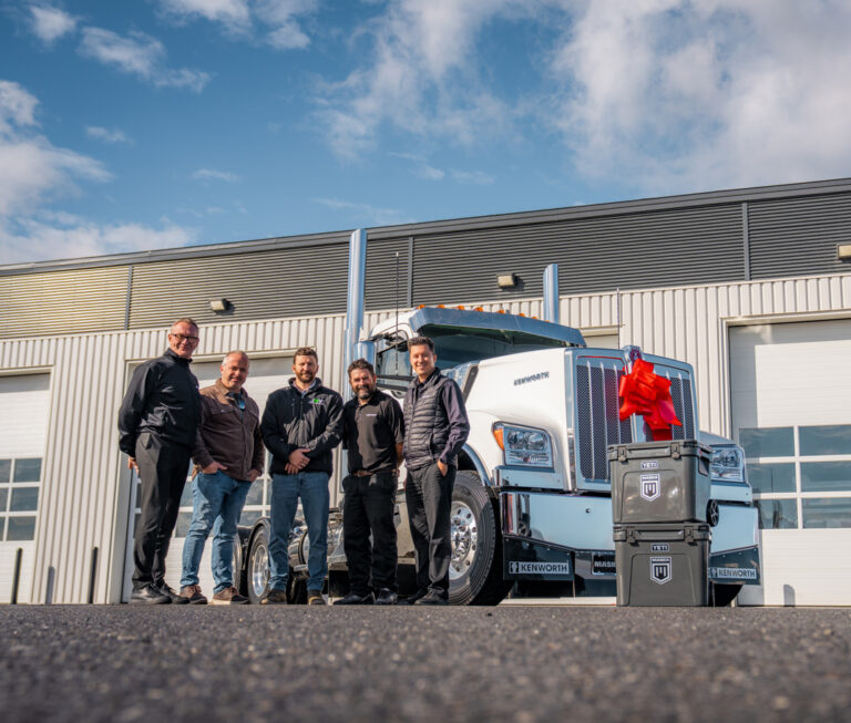 Livraison du Kenworth W990 fabriqué au Québec à Groupe JMV, en présence des représentants de l’entreprise et de l’équipe MASKA, devant le camion neuf.